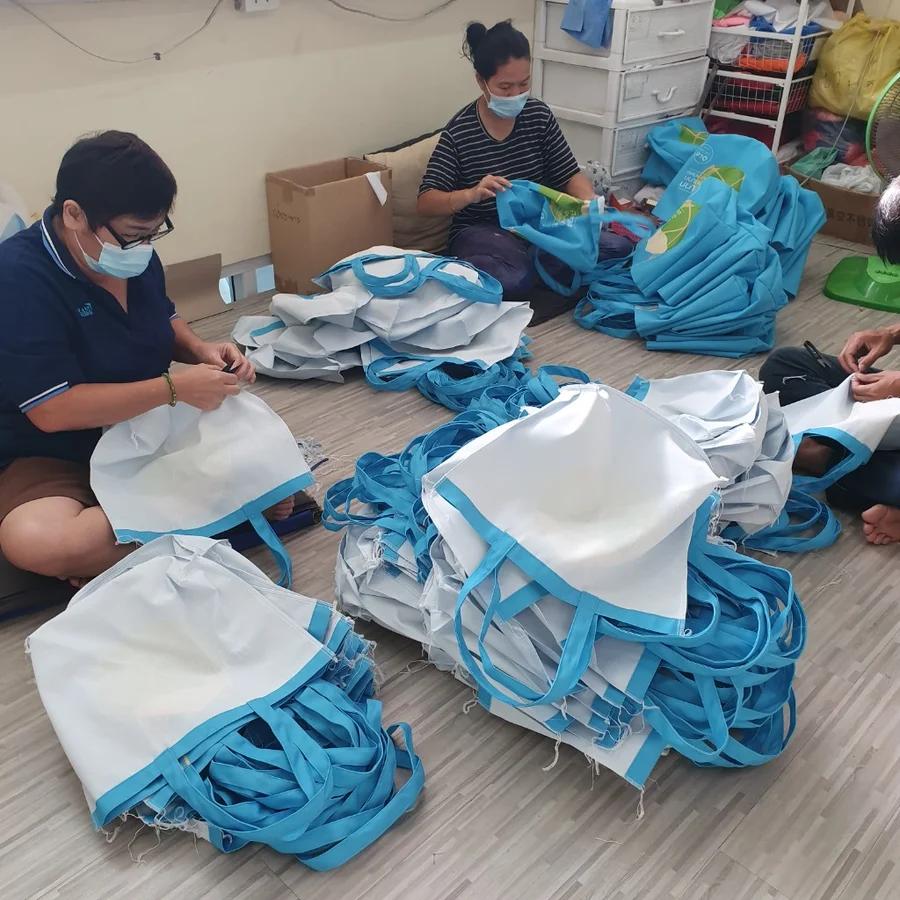 ทีมผลิตตรวจสอบและจัดรียมถุงผ้าในโรงงาน